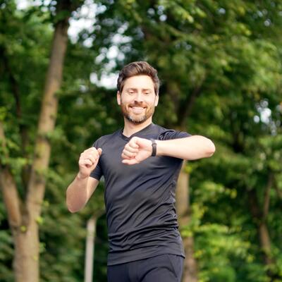 Jogger Mitte 40 blickt auf seine Smartwatch.