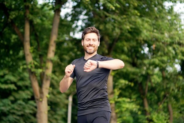 Jogger Mitte 40 blickt auf seine Smartwatch.