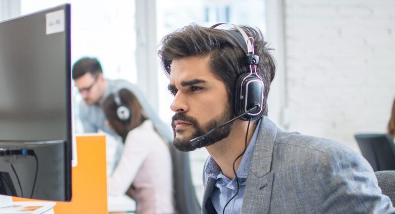 Junger Mann am PC mit Headset