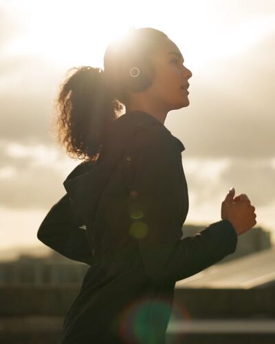 Junge attraktive Joggerin mit Beats und Smartwatch .