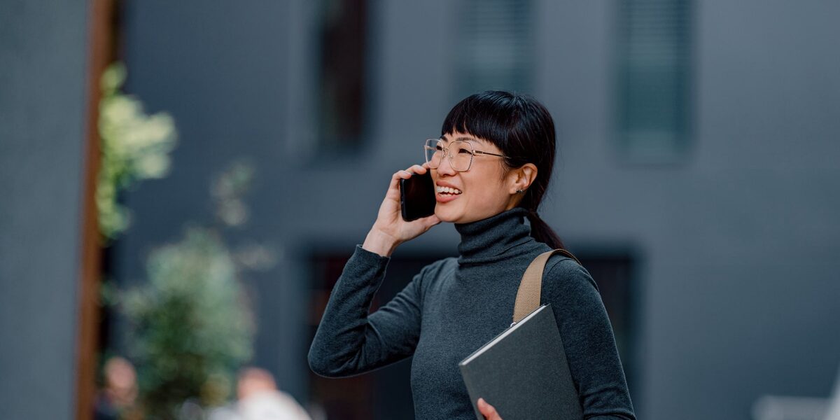 Asiatische Geschäftsfrau mit Brille telefoniert.