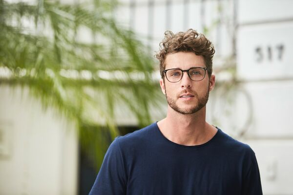 Junger Mann mit Brille blickt in die Kamera.