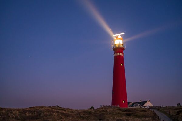 Leuchtturm, der in der Dämmerung leuchtet.