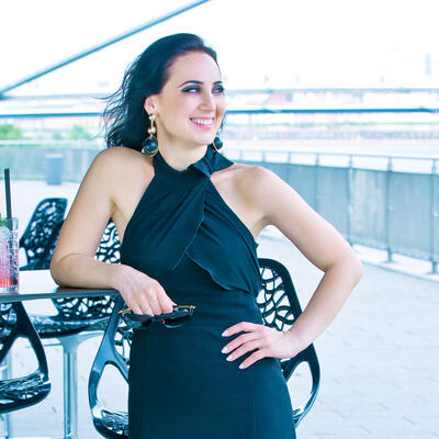 Unsere Patientin nach ihrer Linsen-OP im schwarzen Kleid auf einer Terrasse.