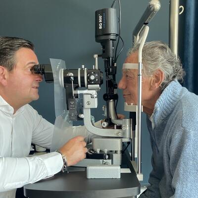 Dr. Breyer untersucht die Augen von Wolfgang Rolshoven an der Spaltlampe.