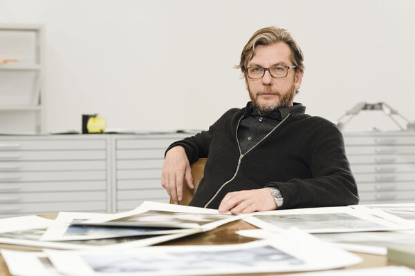 Portrait von Thomas Ruff am Tisch in seinem Atelier.