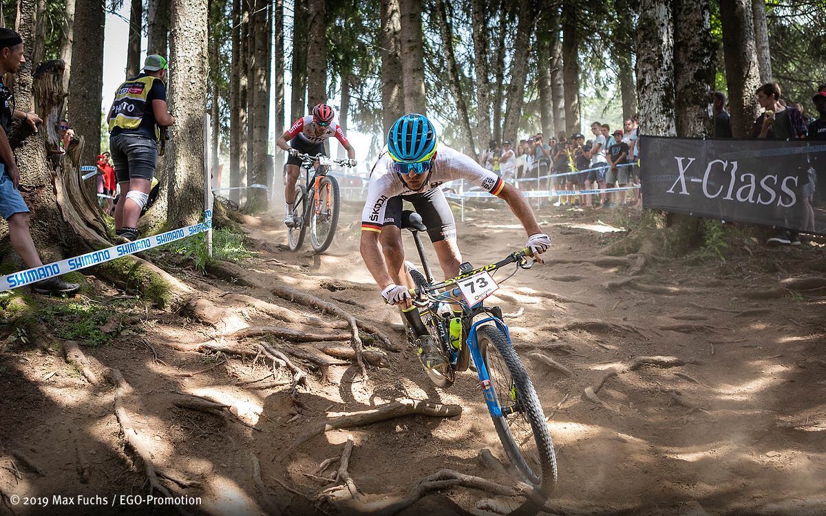Ben Zwiehoff bei einem Cross-Country Rennen durch einen Wald.